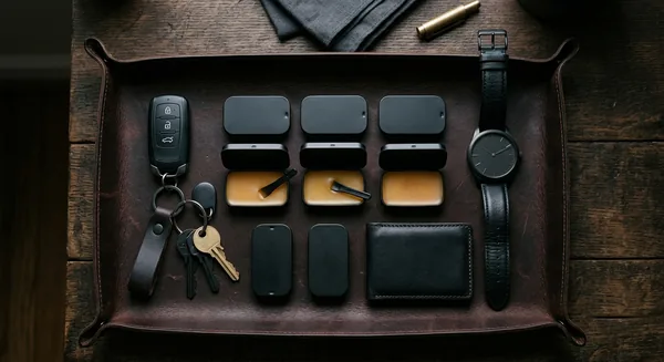 Three tins of solid balm cologne on a leather valet tray